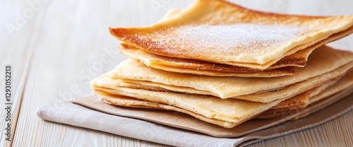 Tall stack of delicious pancakes on a neatly folded napkin with maple syrup and butter ready for breakfast delight