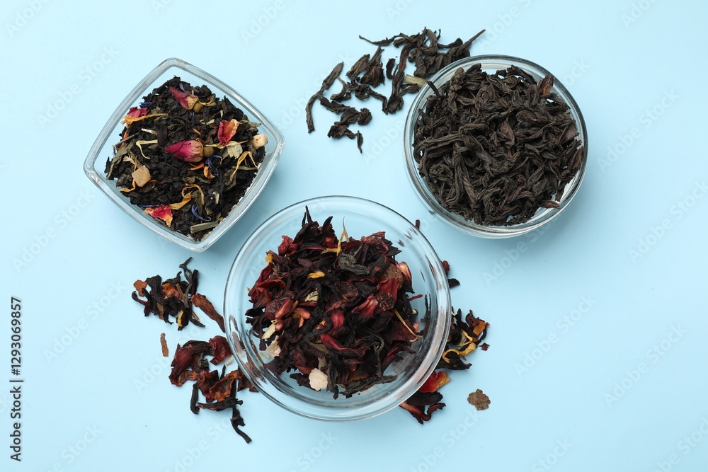 Fototapeta premium Different types of tea brew on light blue background, flat lay