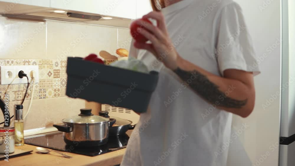 Skilled female home cook pulling fresh vegetables from refrigerator, rinsing produce in kitchen sink while preparing healthy homemade dinner Skilled female home cook pulling fresh vegetables from refrigerator, rinsing produce in kitchen sink while preparing healthy homemade dinner