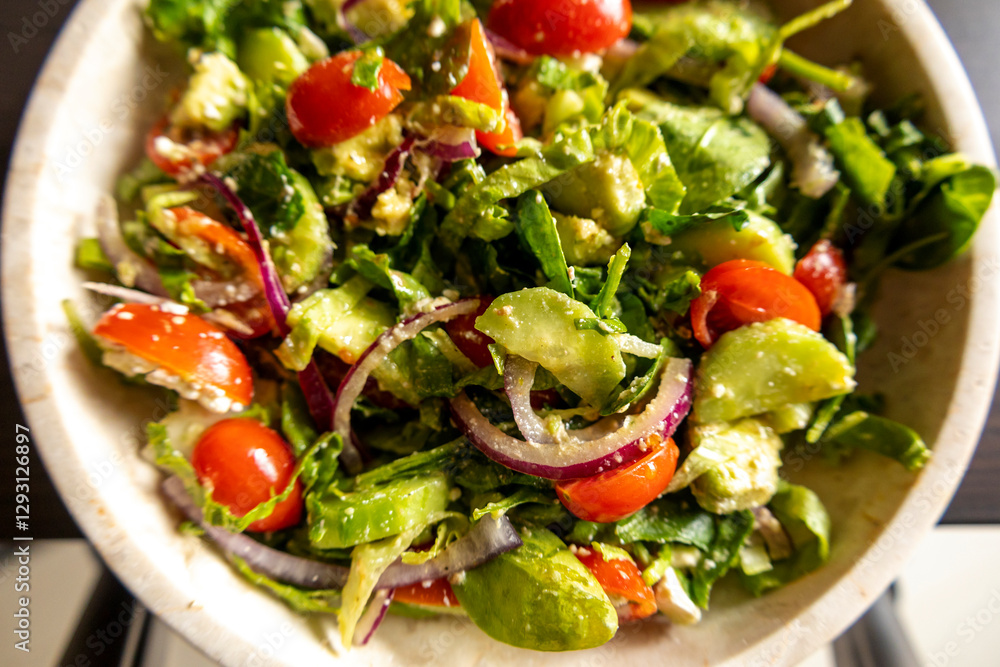 fresh delicious spring salad with lettuce, tomato, cucumber, and feta cheese close-up