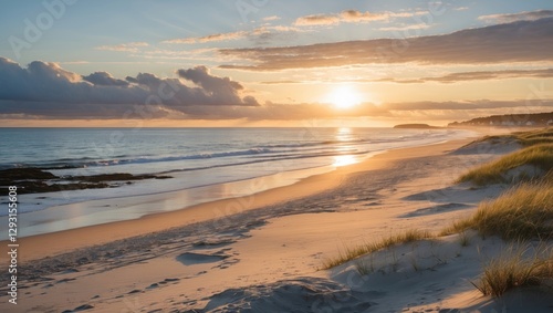 Fototapeta Naklejka Na Ścianę i Meble -  Serene sandy beach at sunrise over Aalbaek Bay, Baltic Sea, North Jutland, Denmark showcasing tranquil ocean waves and soft dunes.