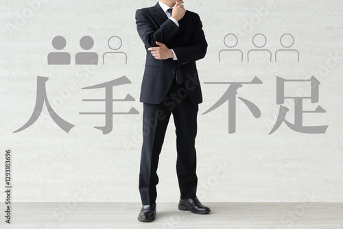 人手不足に悩むスーツを着た男性のイメージ画像