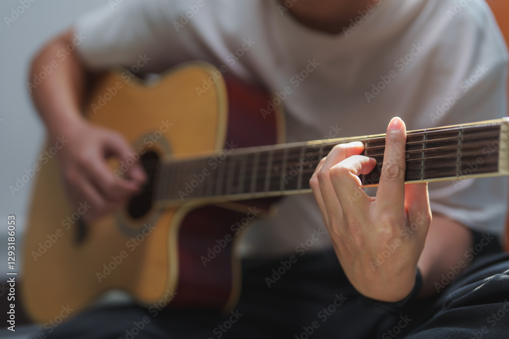 Fototapeta premium Musician playing acoustic guitar, practicing chords and melodies