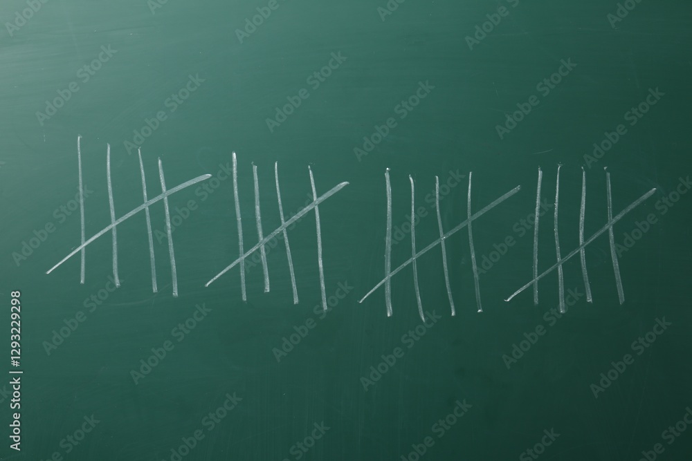Obraz premium Counting days by drawing sticks with chalk on chalkboard, closeup