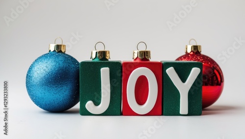 Joy spelled with colorful blocks and Christmas ornaments on a white background symbolizing festive cheer and holiday spirit.