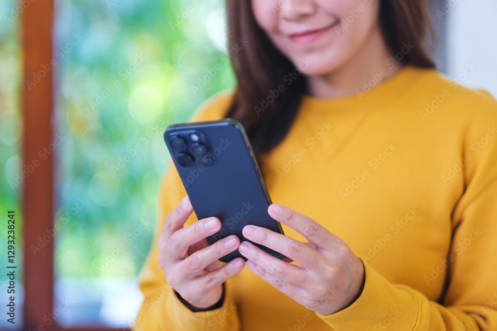 Closeup image of a woman holding and using smart phone at home Closeup image of a woman holding and using smart phone at home