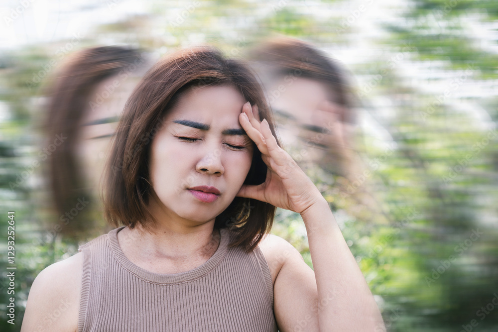Asian woman suffering from anemia, experiencing syncope, dizziness, and vertigo while walking outdoor due to reduced oxygen levels Asian woman suffering from anemia, experiencing syncope, dizziness, and vertigo while walking outdoor due to reduced oxygen levels