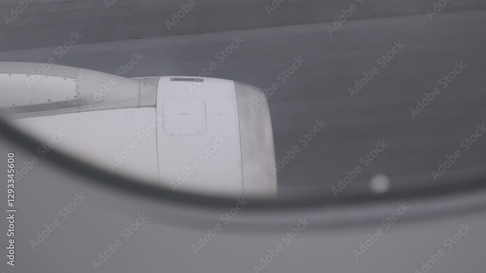 View of airplane engine through window during flight on a cloudy day View of airplane engine through window during flight on a cloudy day