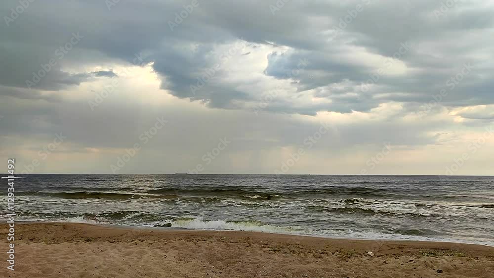 Rain in the sea. View of rain, rain clouds, sandy beach, sea and sea waves with white foam. Cloudy weather. Seascape. Sea landscape. Nature. Natural background Rain in the sea. View of rain, rain clouds, sandy beach, sea and sea waves with white foam. Cloudy weather. Seascape. Sea landscape. Nature. Natural background