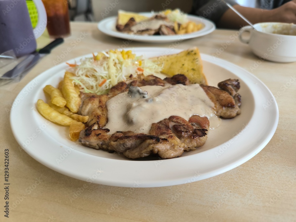 Chicken Steak with Mushroom Cream Sauce french fried and salad delicious food in Thai restuarant Chicken Steak with Mushroom Cream Sauce french fried and salad delicious food in Thai restuarant