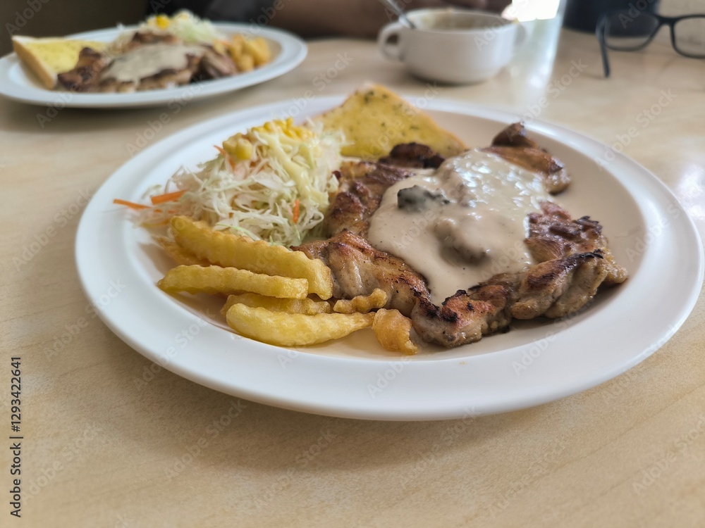 Chicken Steak with Mushroom Cream Sauce french fried and salad delicious food in Thai restuarant Chicken Steak with Mushroom Cream Sauce french fried and salad delicious food in Thai restuarant