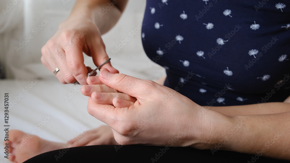 A mother cuts her child's fingernails with scissors. Children's manicure. Body care concept. Carefully home hygiene procedures for hand and nail care. Healthy lifestyle. Close-up body part. Take care. A mother cuts her child's fingernails with scissors. Children's manicure. Body care concept. Carefully home hygiene procedures for hand and nail care. Healthy lifestyle. Close-up body part. Take care.