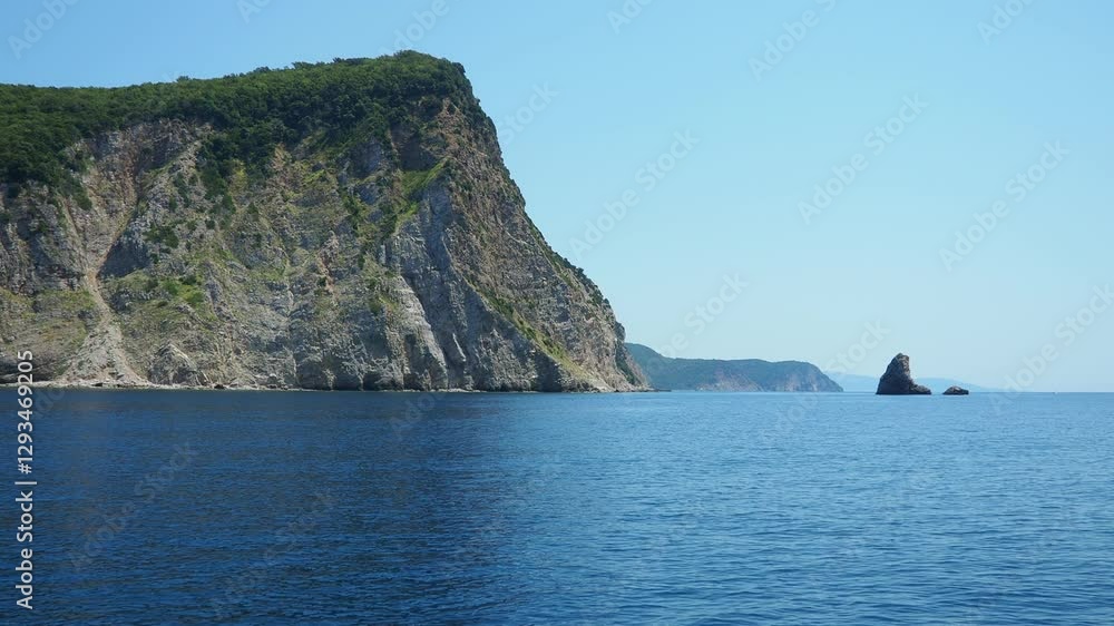 Majestic cliffs rising above clear blue waters along a remote coastline. Picturesque landscape showcases nature beauty in peaceful setting. RT Dubovica Rocks near Buljarica, Svetac Rock, Montenegro. Majestic cliffs rising above clear blue waters along a remote coastline. Picturesque landscape showcases nature beauty in peaceful setting. RT Dubovica Rocks near Buljarica, Svetac Rock, Montenegro.