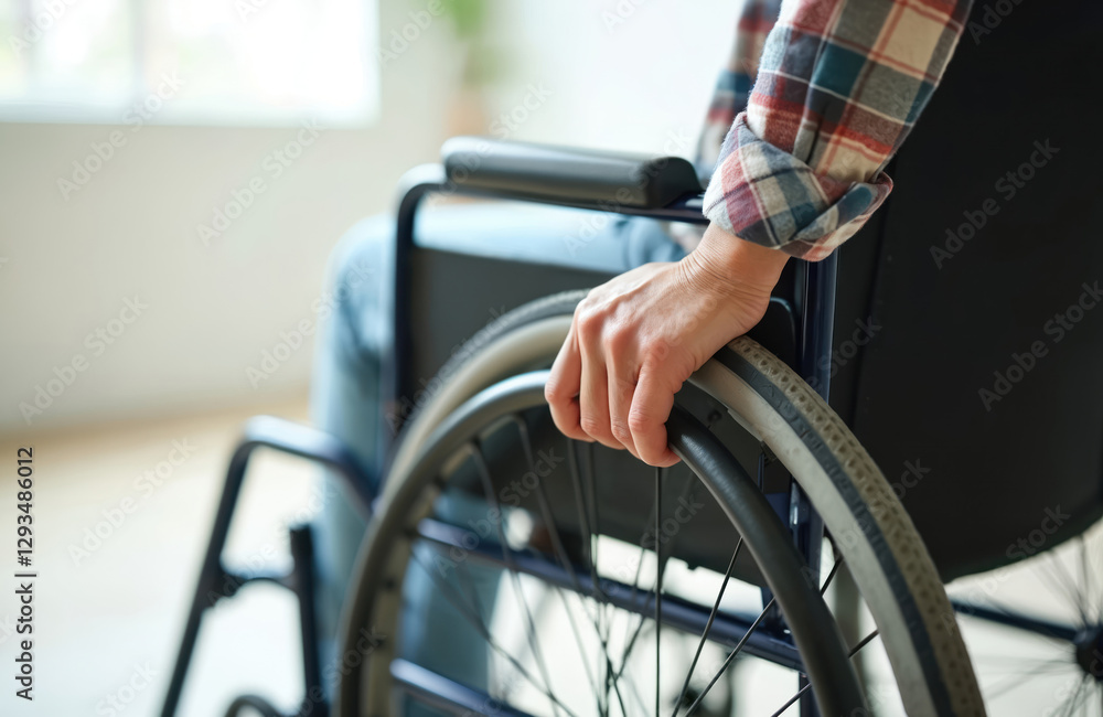 Close-up of woman hand on wheelchair wheel. Person using wheelchair indoors. Accessibility, independence. Woman sits in casual attire. Rehabilitation, mobility concept. Medical assistance, health Close-up of woman hand on wheelchair wheel. Person using wheelchair indoors. Accessibility, independence. Woman sits in casual attire. Rehabilitation, mobility concept. Medical assistance, health