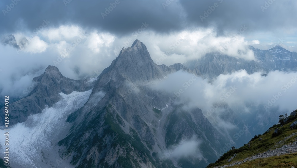 Fototapeta premium Majestic mountain peaks rising through clouds with dramatic lighting and rugged terrain capturing the essence of alpine adventure and tranquility.