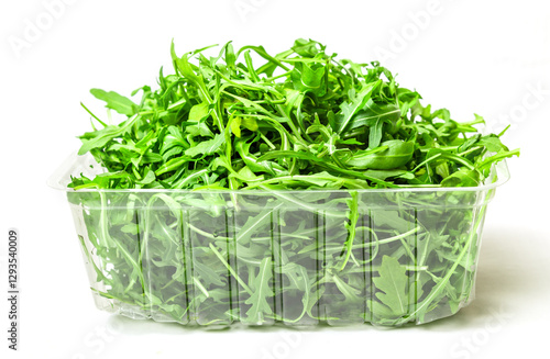 Fresh arugula in a clear plastic container. Crisp greens, ready for salad or garnish. Healthy, vibrant, and delicious! Isolated on white