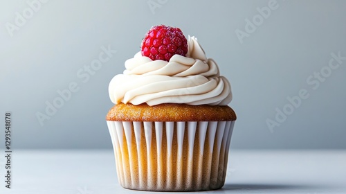 Delicious cupcake topped with creamy frosting and fresh raspberr photo