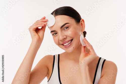 Wallpaper Mural Smiling person caring for their skin using cotton pads promotes healthy facial skincare habits. Torontodigital.ca