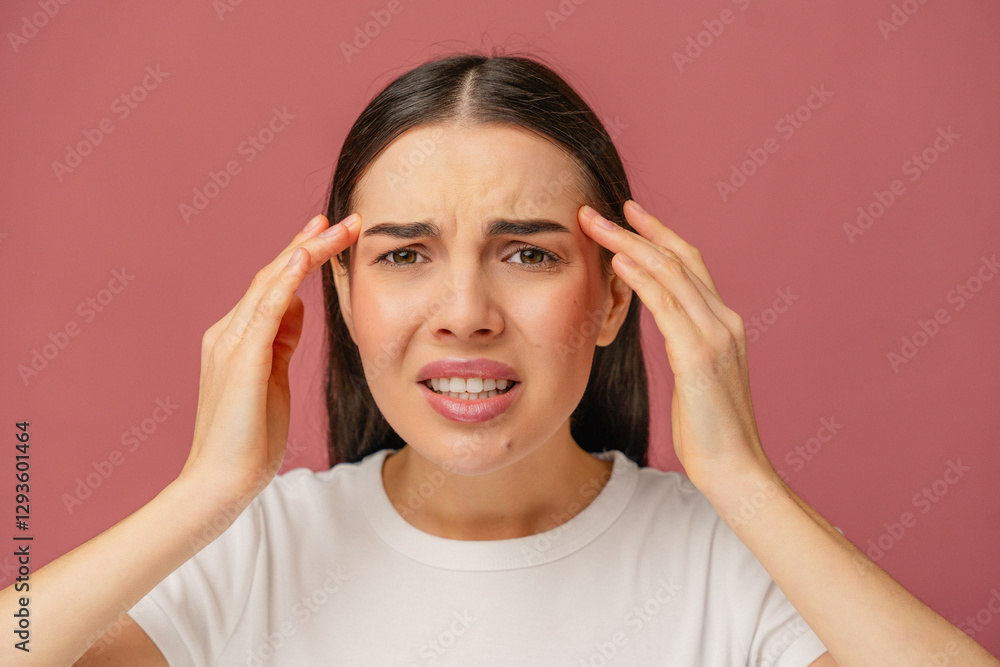 Female individual holding head with a distressed and uncomfortable expression, showcasing human emotions and reactions. Female individual holding head with a distressed and uncomfortable expression, showcasing human emotions and reactions.
