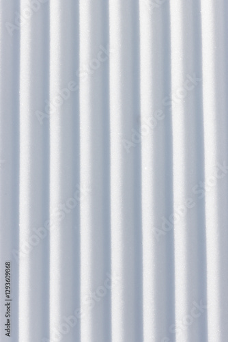 Straight vertical line grooves in white snow surface textured background