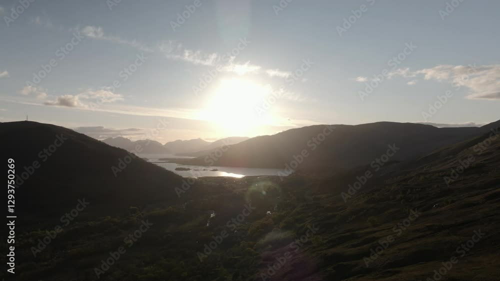 Drone shot of Glencoe on a summer evening, featuring sun flare, sea and mountains Drone shot of Glencoe on a summer evening, featuring sun flare, sea and mountains