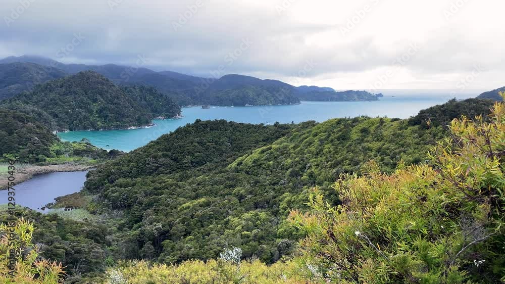 Breathtaking view from Abel Tasman Torrent Bay lookout, lush green hills, turquoise ocean and dramatic skies. Breathtaking view from Abel Tasman Torrent Bay lookout, lush green hills, turquoise ocean and dramatic skies.