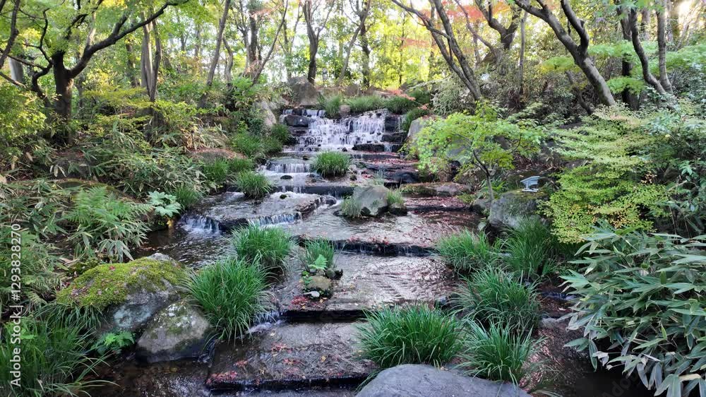 Serene waterfall surrounded by lush greenery at Kokoen Garden ,Himeji, Japan Serene waterfall surrounded by lush greenery at Kokoen Garden ,Himeji, Japan
