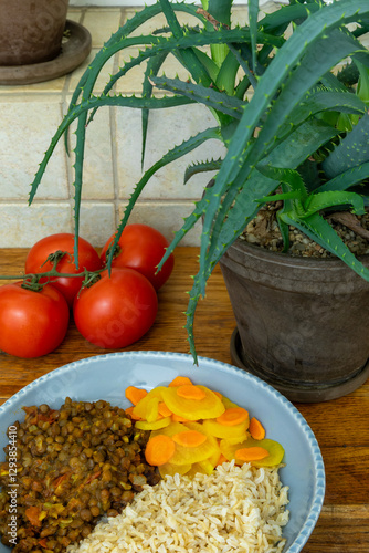 A dish made of sprouted fenugreek seeds, dried Nepali small peas, and jimbu herbs served with rice and pickled radish with turmeric. Tomatoes and aloe vera behind.  photo