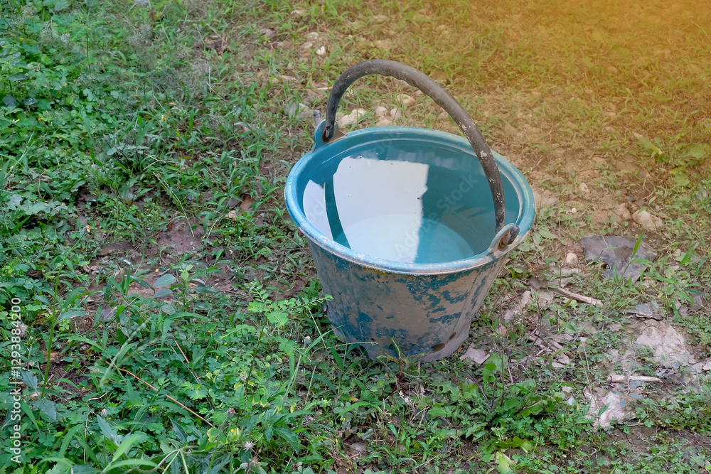 Blue plastic bucket on yard,Bucket used to keep and fill water. Narrow focus image. Blue plastic bucket on yard,Bucket used to keep and fill water. Narrow focus image.