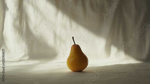 Golden pear in spotlight, simple and natural food photography, with a soft light and a white fabric. Still life, minimalist, simplicity, fruit.