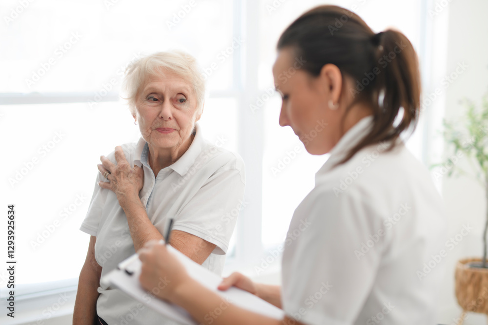 physiotherapist helping senior woman in clinic. Elderly woman undergoing physiotherapy treatment for injury physiotherapist helping senior woman in clinic. Elderly woman undergoing physiotherapy treatment for injury