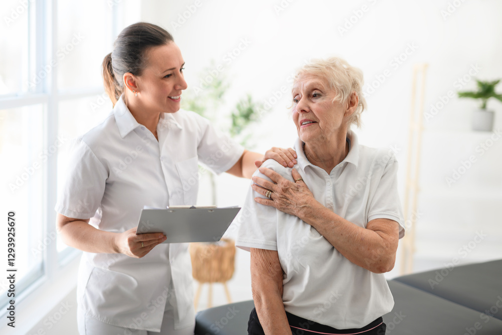 Fototapeta premium physiotherapist helping senior woman in clinic. Elderly woman undergoing physiotherapy treatment for injury