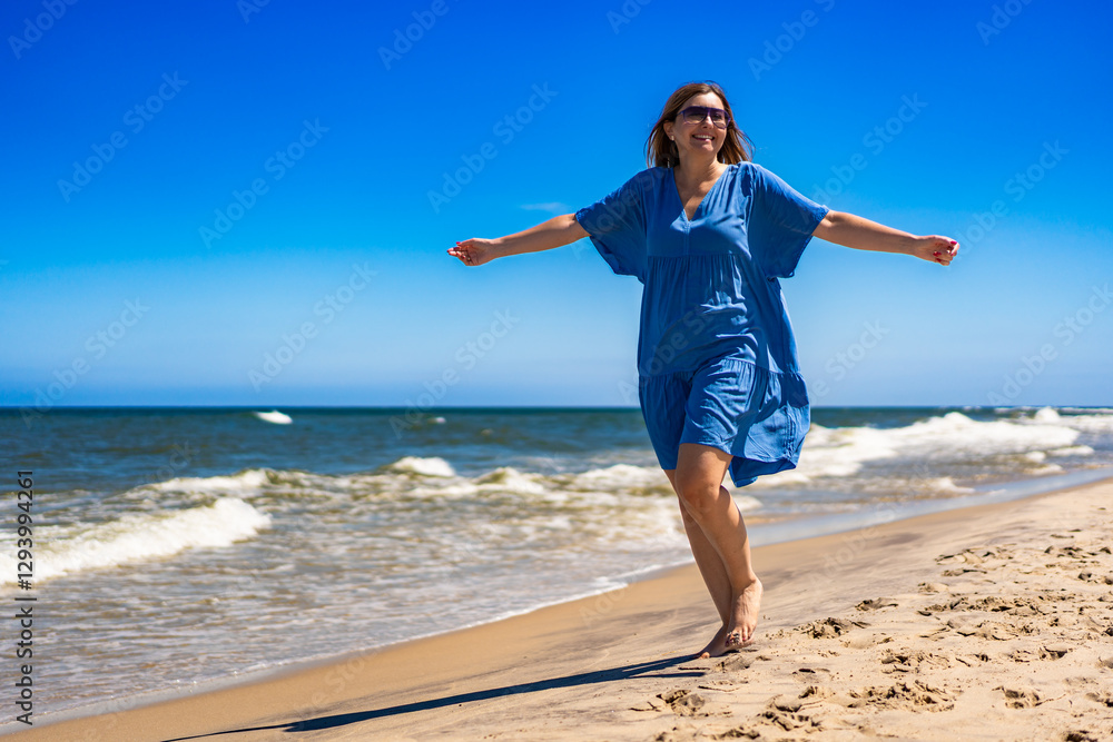 Portrait of beautiful middle-aged woman enjoying walk on sandy beach on sunny summer day Portrait of beautiful middle-aged woman enjoying walk on sandy beach on sunny summer day