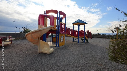 Wallpaper Mural A vibrant yet deserted playground near the sea at dusk. The bright colors suggest joy, but the emptiness under cloudy skies evokes nostalgia and solitude. Torontodigital.ca