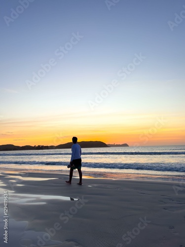 Lone figure on sunset beach