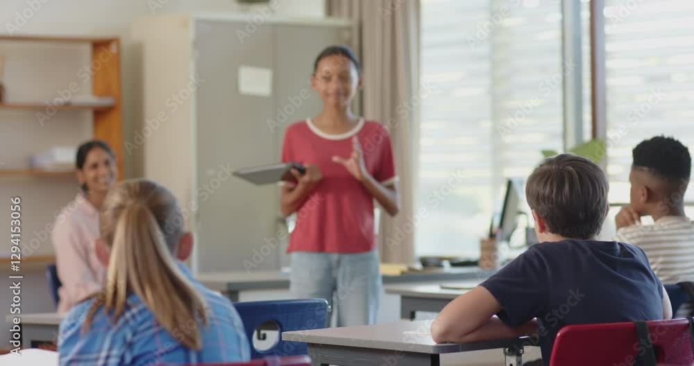 In school, girl presenting with tablet in classroom, engaging with classmates In school, girl presenting with tablet in classroom, engaging with classmates