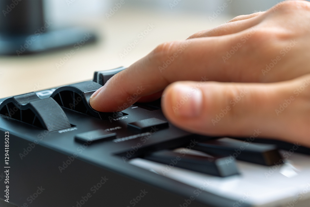Woman playing MIDI keyboard with control knobs and pads, close-up. Woman playing MIDI keyboard with control knobs and pads, close-up.