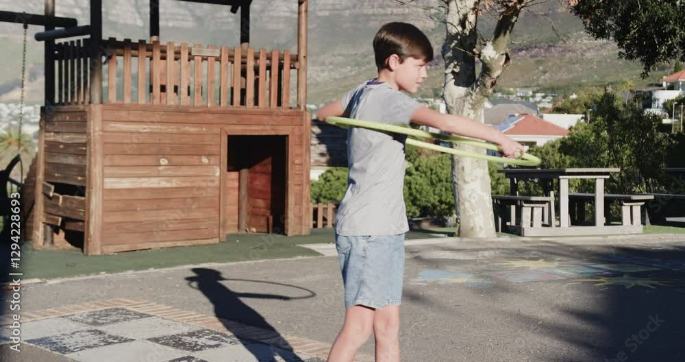 Playing with hula hoop, boy enjoying outdoor activity at school playground Playing with hula hoop, boy enjoying outdoor activity at school playground