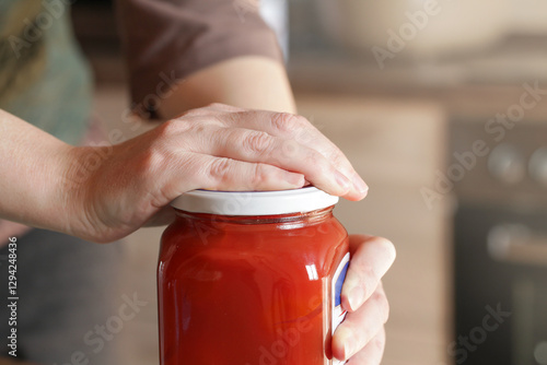 Open Stuck Jar. Problem when working with tightly closed Jars with Pickled. Woman Opening Glass Jar with preserved tomatoes