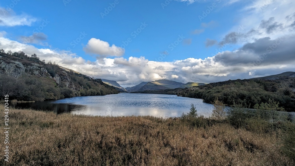 Picturesque lake and mountains at Brynrefail, Wales. Captured in natural autumn light with vibrant blue skies and serene water. Perfect for travel and nature content. Picturesque lake and mountains at Brynrefail, Wales. Captured in natural autumn light with vibrant blue skies and serene water. Perfect for travel and nature content.