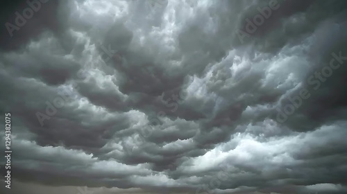 Fototapeta Naklejka Na Ścianę i Meble -  A moody sky filled with grey clouds, with slivers of blue sky breaking through, offering a unique contrast of tones.