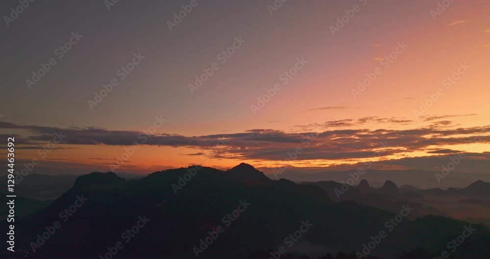 A breathtaking Aerial view of a mountain range at sunrise, with mist rolling over the lush green forest. The dramatic sky and layers of fog create a serene and mystical atmosphere at Baan Jabo. A breathtaking Aerial view of a mountain range at sunrise, with mist rolling over the lush green forest. The dramatic sky and layers of fog create a serene and mystical atmosphere at Baan Jabo.