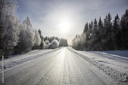 Verschneite Landstrasse mit Schneefahrbahn im  Winter