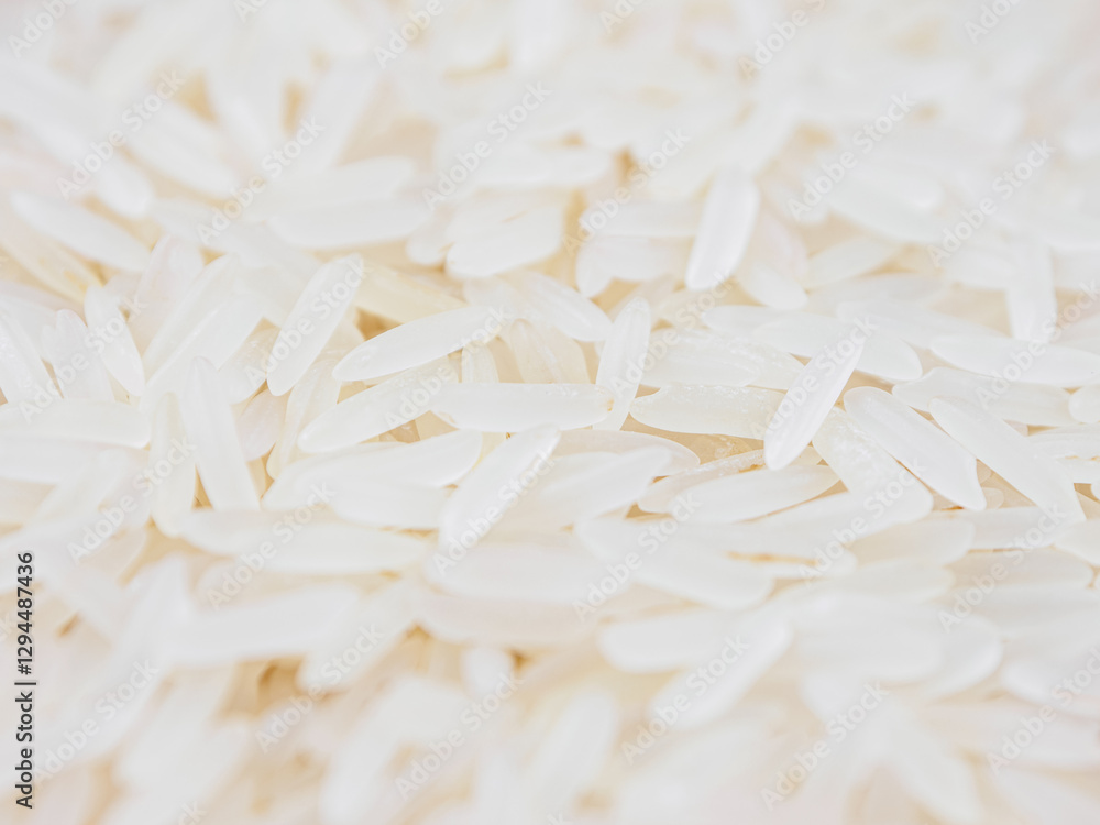Obraz premium Close-up shot of dry, uncooked long grain basmati rice. Grains are slender and translucent, natural texture.