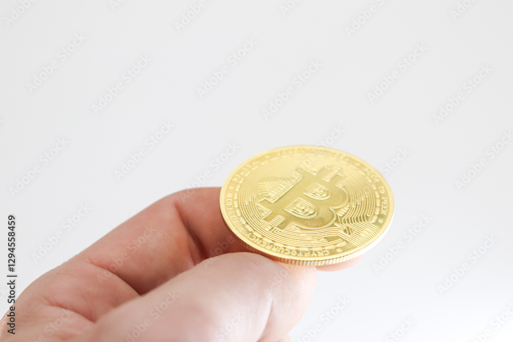 Close-up of a hand making the gesture of throwing a bitcoin on a white background. Heads or tails concept, risk of purchase. Close-up of a hand making the gesture of throwing a bitcoin on a white background. Heads or tails concept, risk of purchase.