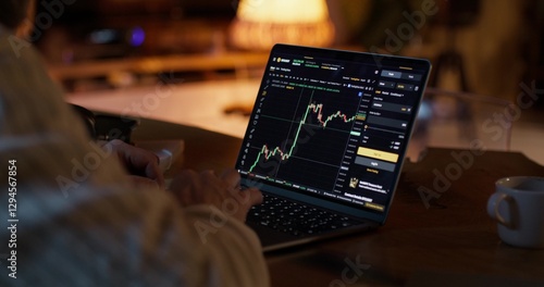Papier peint A man participates in trading on the stock exchange, he uses a laptop while sitting at a desk at home