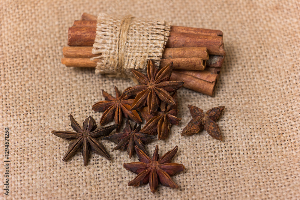 Star anise and cinnamon on burlap background, aromatic spices for cooking and baking Star anise and cinnamon on burlap background, aromatic spices for cooking and baking