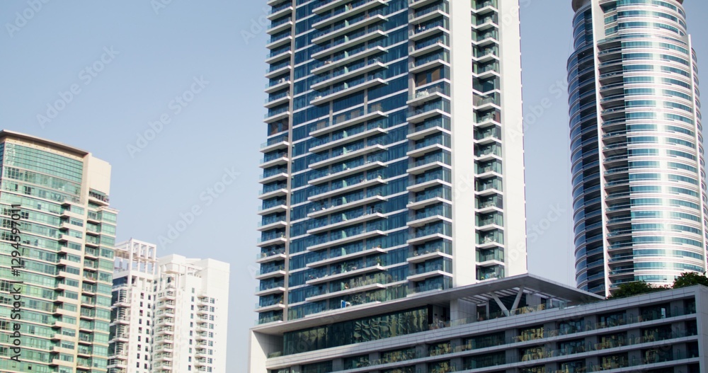 The facade of a glass skyscraper against a cloudless sky, close-up. The facade of a glass skyscraper against a cloudless sky, close-up.