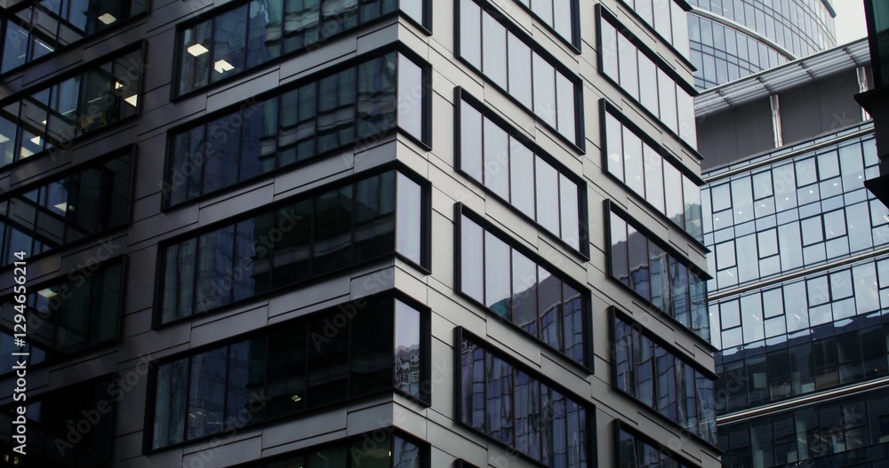 Facade of modern office buildings with large panoramic windows. Semicircular glass skyscraper in the business center of the city. Dynamic shooting from the bottom up. Video in 4k, red komodo Facade of modern office buildings with large panoramic windows. Semicircular glass skyscraper in the business center of the city. Dynamic shooting from the bottom up. Video in 4k, red komodo