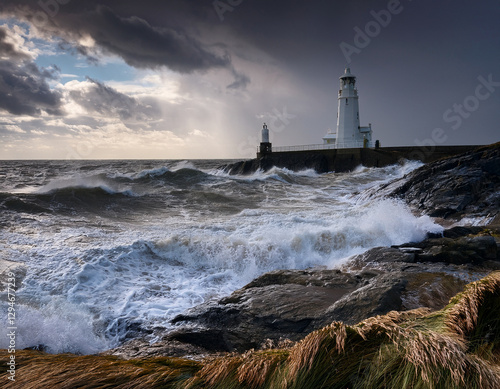Canvas Print A serene British coastline with a lighthouse and choppy waves under a stormy sky